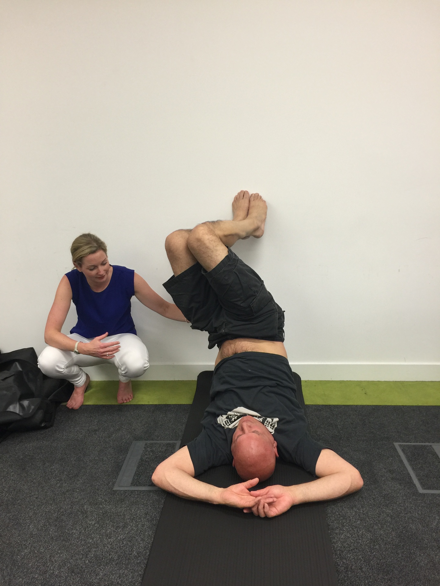 Patient performing a spinal decompression exercise using the BackBlock with practitioner guidance